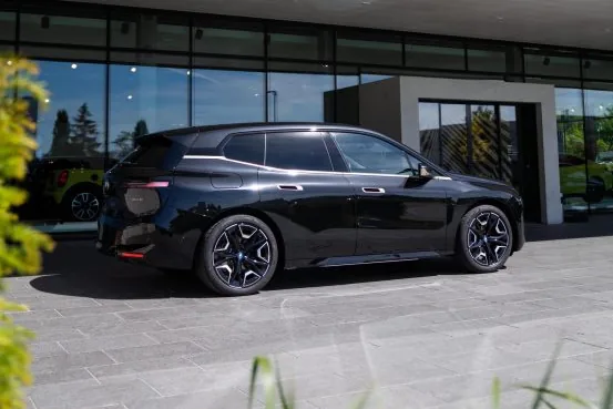BMW iX xDrive50 rear three-quarter view showing the roofline and aero wheels